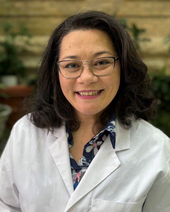 Portrait of Dr. Karimi Minuzzi Tookuni wearing a white coat. 