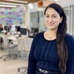Portrait of Oksana Harasemiw in a room with many computers on desks.