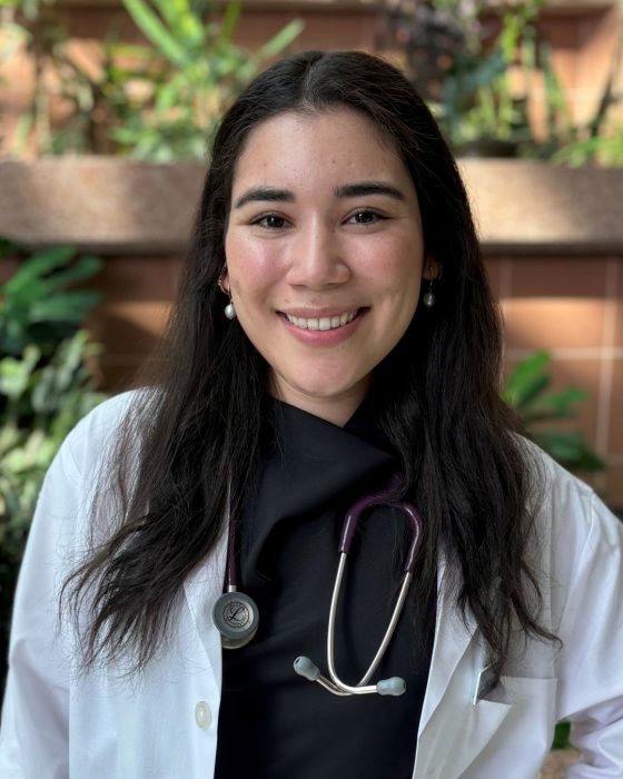 Portrait of Yuxi Ramirez. She is wearing a white coat and a stethoscope around her neck.