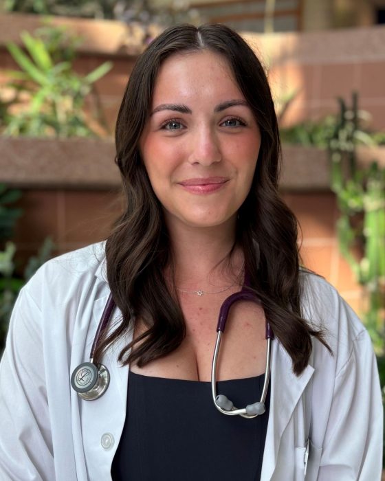 Portrait of Sydney Larence. She is wearing a white coat and a stethoscope around her neck.