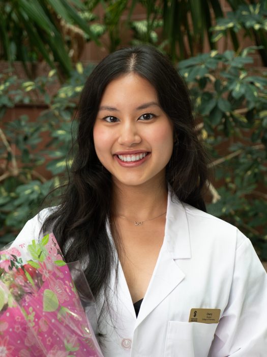 Cherry Nguyen, College of Pharmacy student in white coat, smiling at the camera.