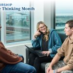 Three students smiling and having a conversation on the UM campus.