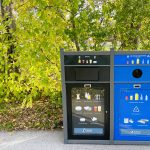Waste and recycling bin in front of greenery