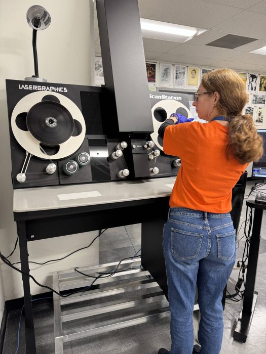 A Digitization Centre staff member adding film to the film scanner