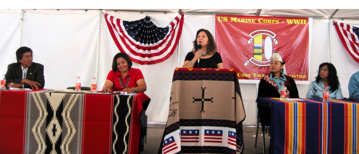 Alt text: A woman speaks at a podium during a Navajo Code Talkers event.