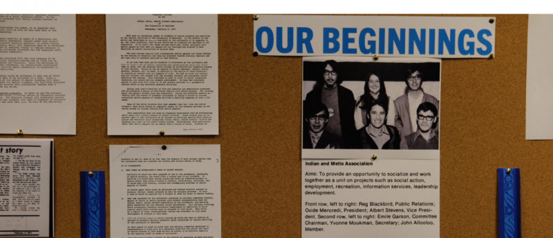 Bulletin board display titled “Our Beginnings” featuring early documents and a black-and-white photo of the Indian and Métis Association.