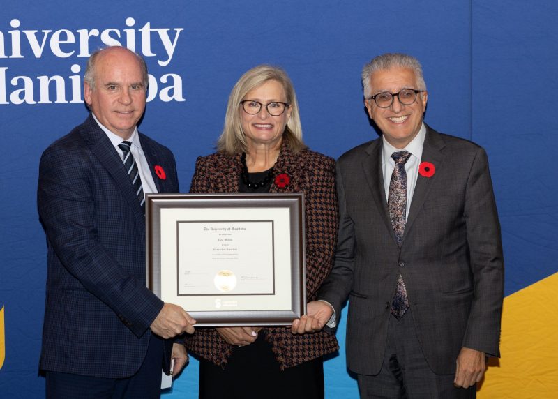 Chancellor Dave Angus and President Michael Benarroch present Anne Mahon with certificate.