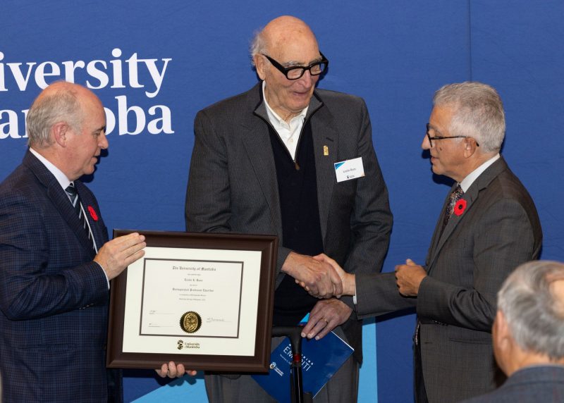 Chancellor Dave Angus and President Michael Benarroch present Leslie Roos with certificate.