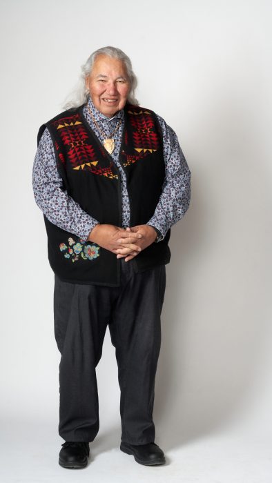 Murray Sinclair poses against a white wall.
