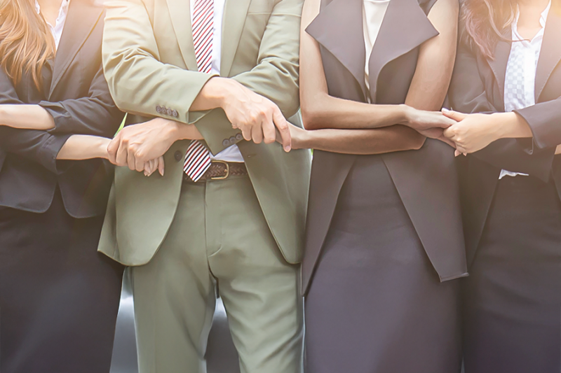 Business professionals join hands in partnership