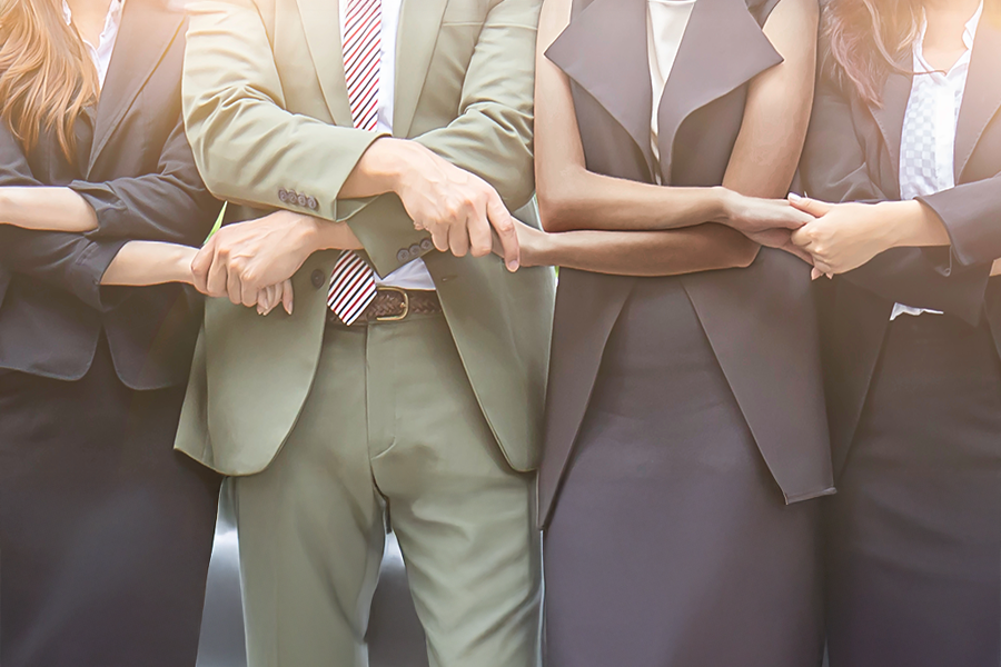 Business professionals join hands in partnership