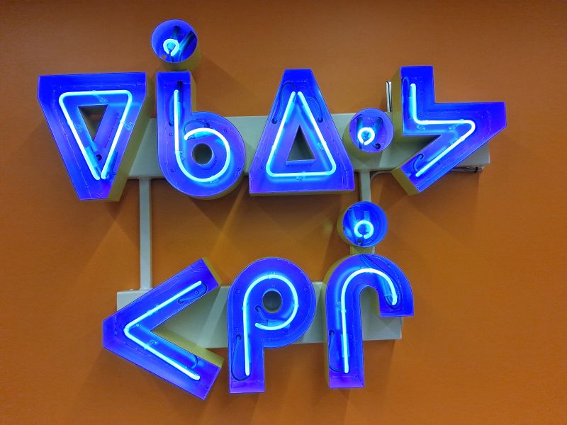 A neon sign that says Don't Give up in Cree - art by Joi T Arcand