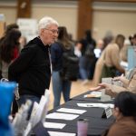 Two people talking by a event booth.