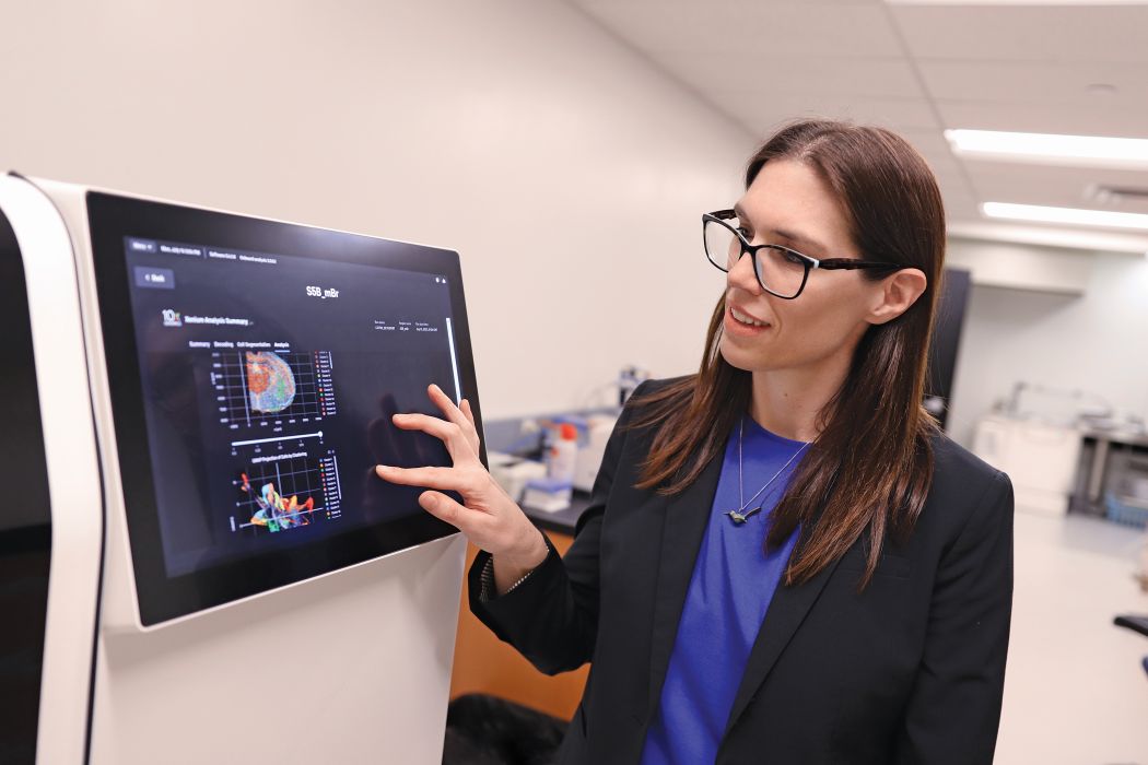 Dr. Britt Drogemoller points to a screen showing spatial maps of gene expression in a mouse brain.