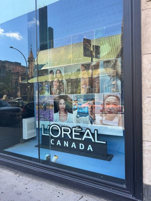 L’Oréal Canada logo with an image collage featured in a window display at the Montreal headquarters.