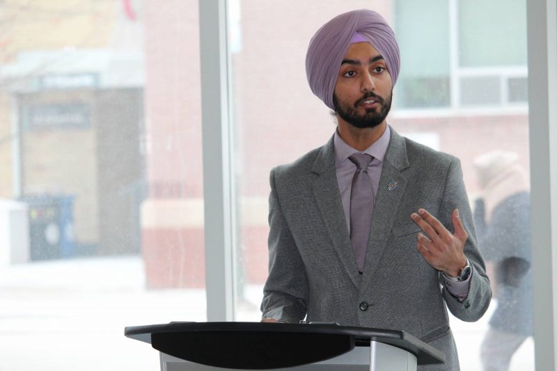 Prabhnoor Singh speaks at a podium at Bannatyne campus.