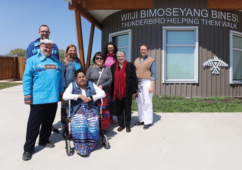 Eight people pose for a group photo outside Wiiji Bimoseyang Binesi.