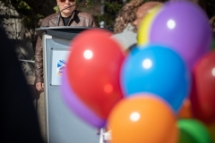 Dr. Fenton Litwiller at the flag raising ceremony, rainbow balloons in the foreground.