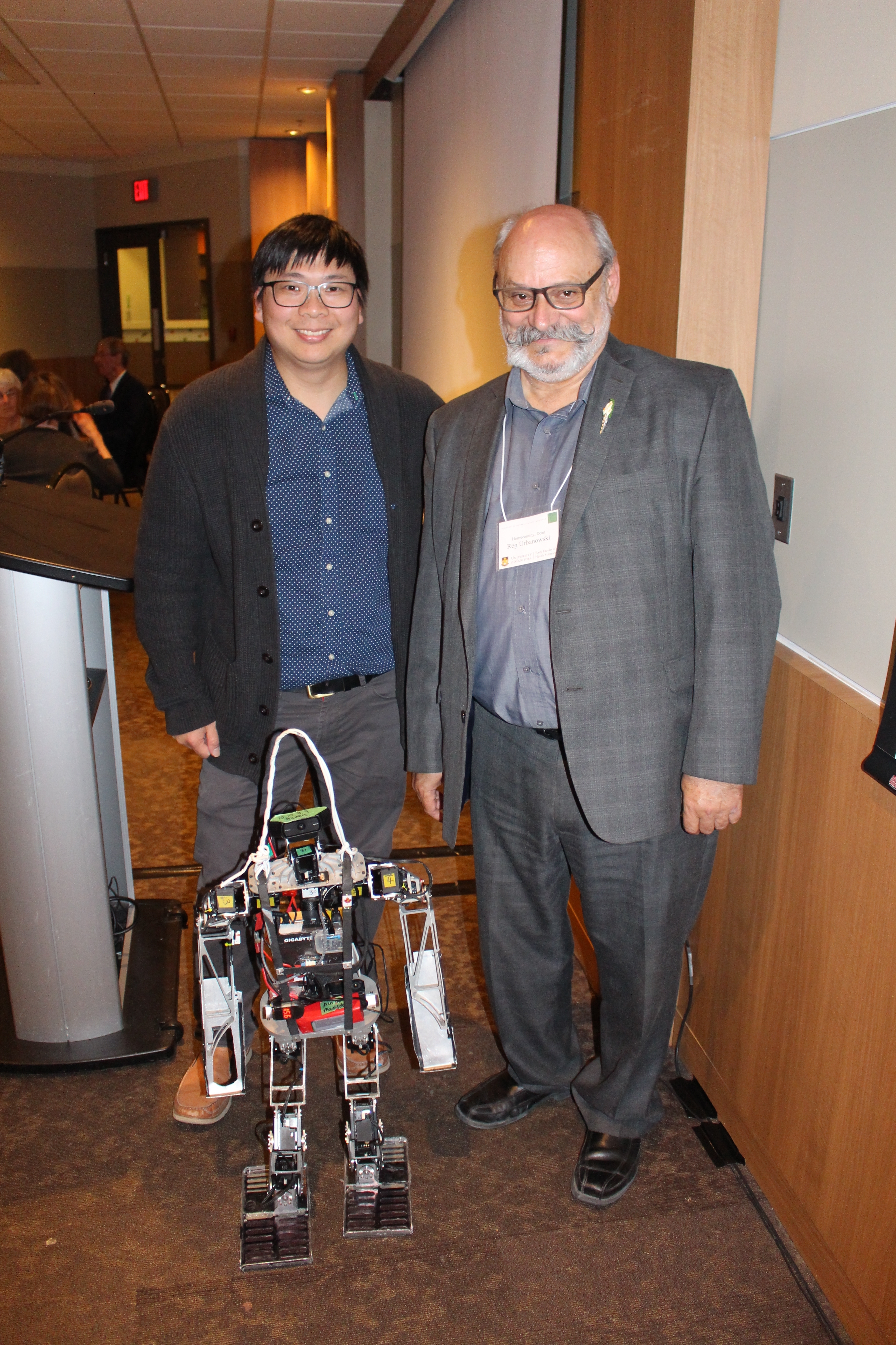 MENG CHENG LAU AND COLLEGE OF REHABILITATION SCIENCES DEAN REG URBANOWSKI WITH POLARIS ROBOT CoRS_Homecoming_2018_05