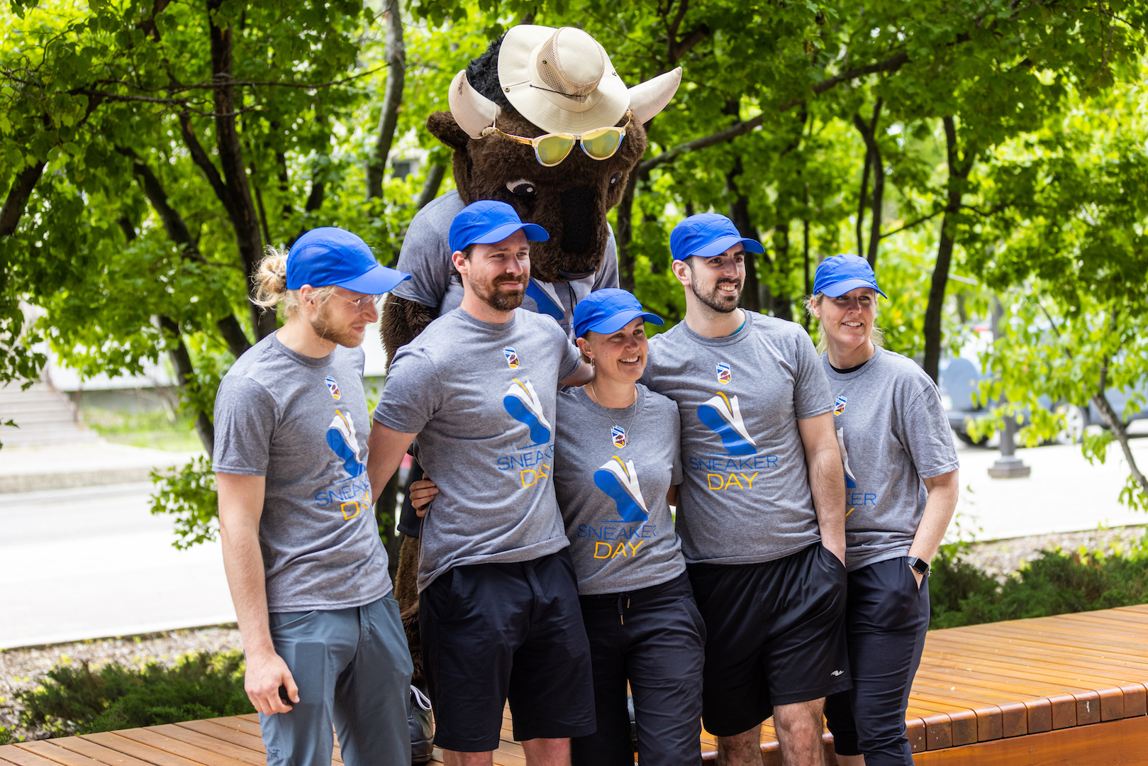 Billy the Bison poses with some people wearing Sneaker Day T-shirts.