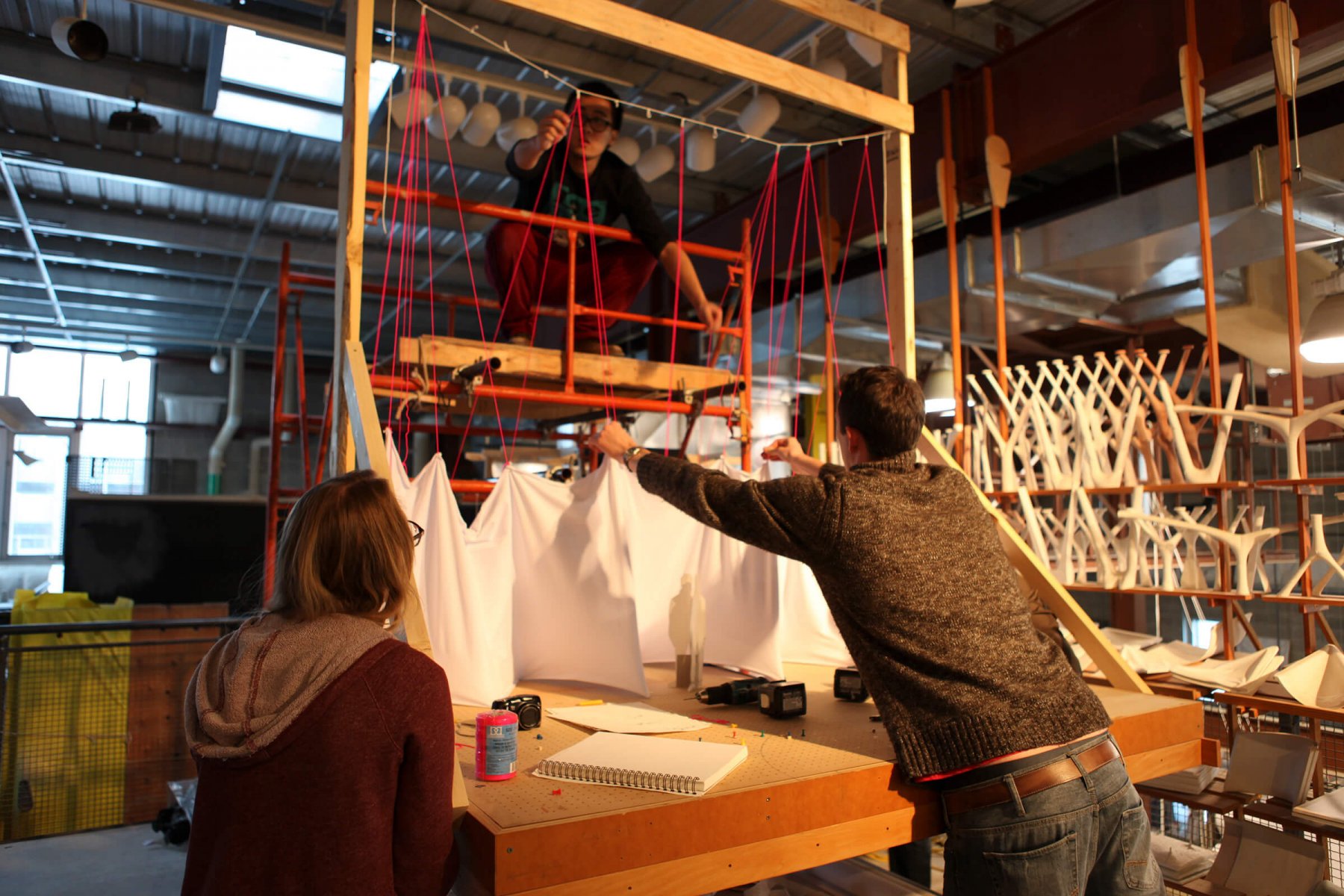 Students work at a frame with cloth at the Centre for Architectural Structures and Technology. Photo by Lancelot Coa