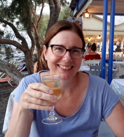 Joanne Crozier smiles at the camera holding a drink